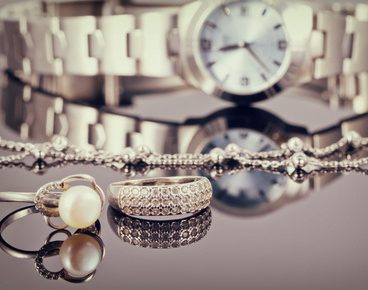 Elegant ring made of silver and silver chain lies in the background of women's watches