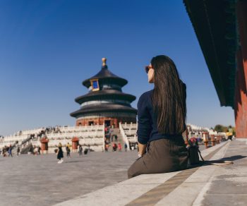 brunette girl sitting on the steps by temple of heven in China brunette girl sitting on the steps by temple of heaven in China. Brunette girl enjoying chinese architecture while sitting on the steps and relaxing. Caucasian tourist taking a break from exploring Beijing China by taking some time to herself.