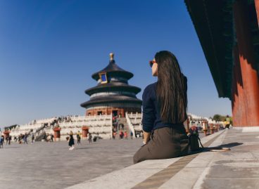 brunette girl sitting on the steps by temple of heven in China brunette girl sitting on the steps by temple of heaven in China. Brunette girl enjoying chinese architecture while sitting on the steps and relaxing. Caucasian tourist taking a break from exploring Beijing China by taking some time to herself.