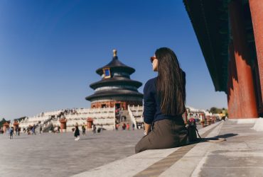 brunette girl sitting on the steps by temple of heven in China brunette girl sitting on the steps by temple of heaven in China. Brunette girl enjoying chinese architecture while sitting on the steps and relaxing. Caucasian tourist taking a break from exploring Beijing China by taking some time to herself.