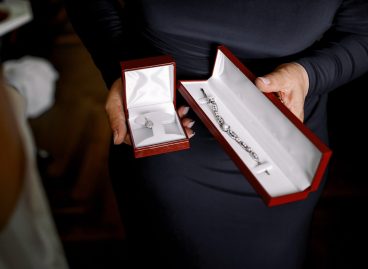 Lady in black dress holds red velvet boxes with jewels Lady in black dress holds red velvet boxes with jewels