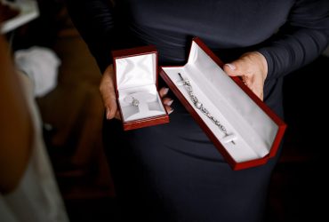 Lady in black dress holds red velvet boxes with jewels Lady in black dress holds red velvet boxes with jewels