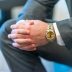 A shallow focus shot of a man in suit clasping his hands with a blurred background